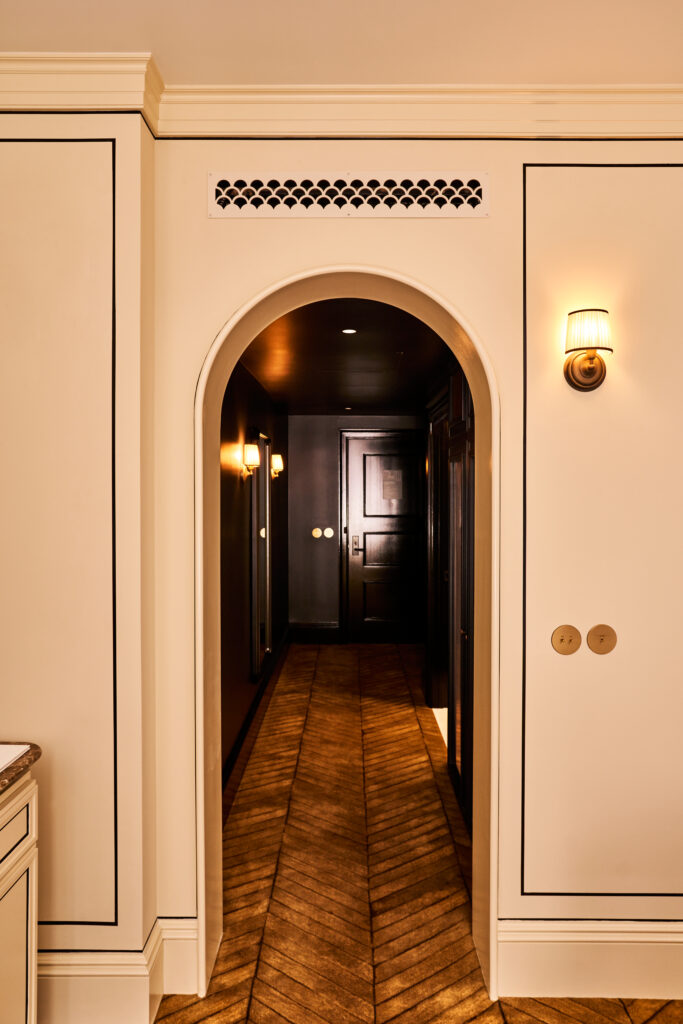 Corridor leading to a Deluxe Room at The Twenty Two New York, showcasing elegant design and a refined ambiance.